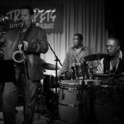 A group of men playing instruments in front of a microphone.